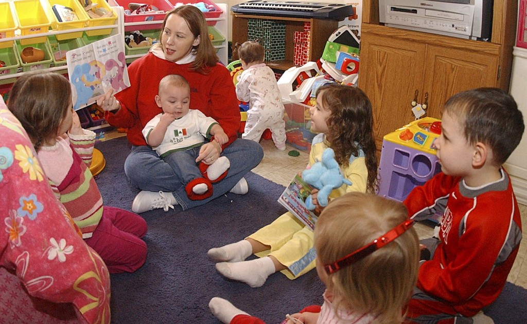 Nursery worker reading to children