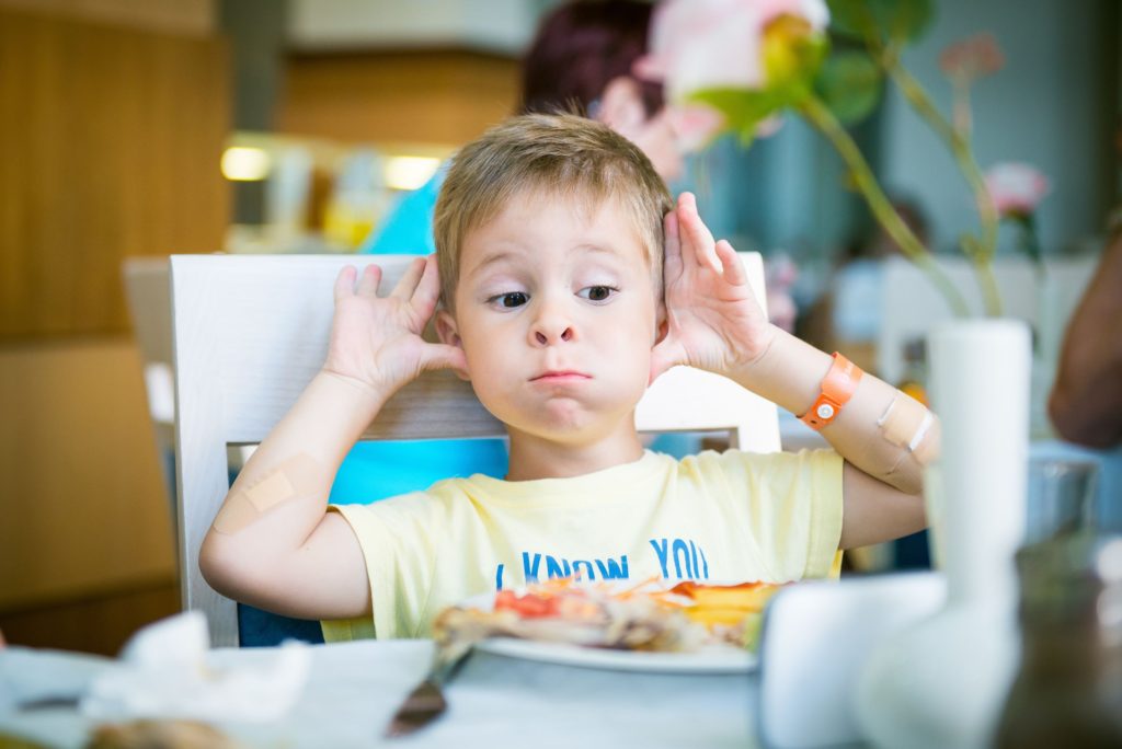 a toddler pulling faces in a restaurant