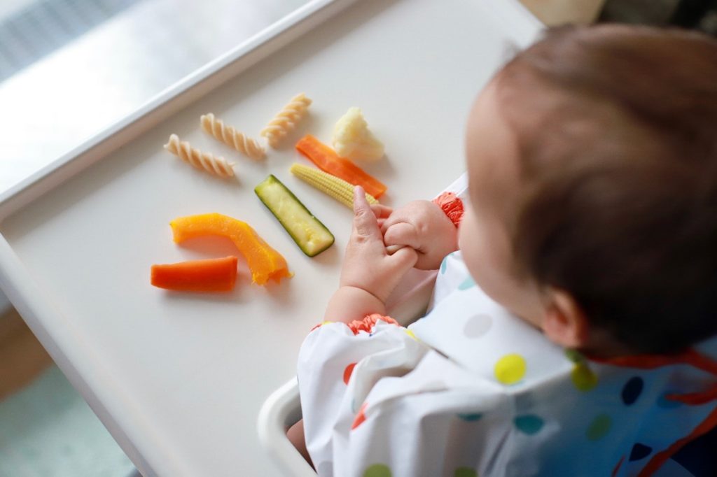 Baby in high chair with finger foods
