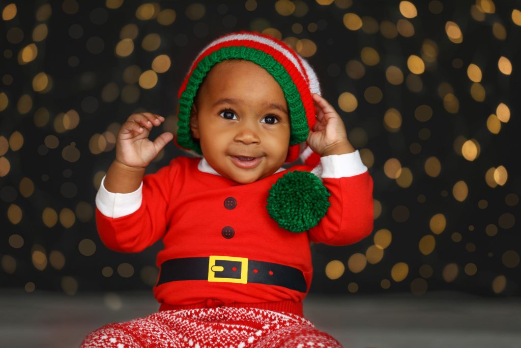 Cute baby smiling whilst in a Santa costume