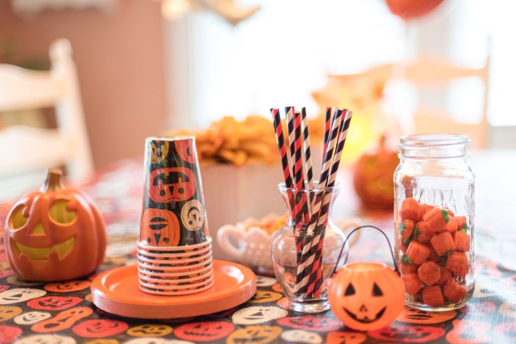 Black and orange cups and straws in a Halloween theme set on a table