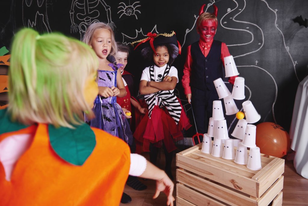 Children dressed up in fun Halloween costumes whilst playing a Halloween 