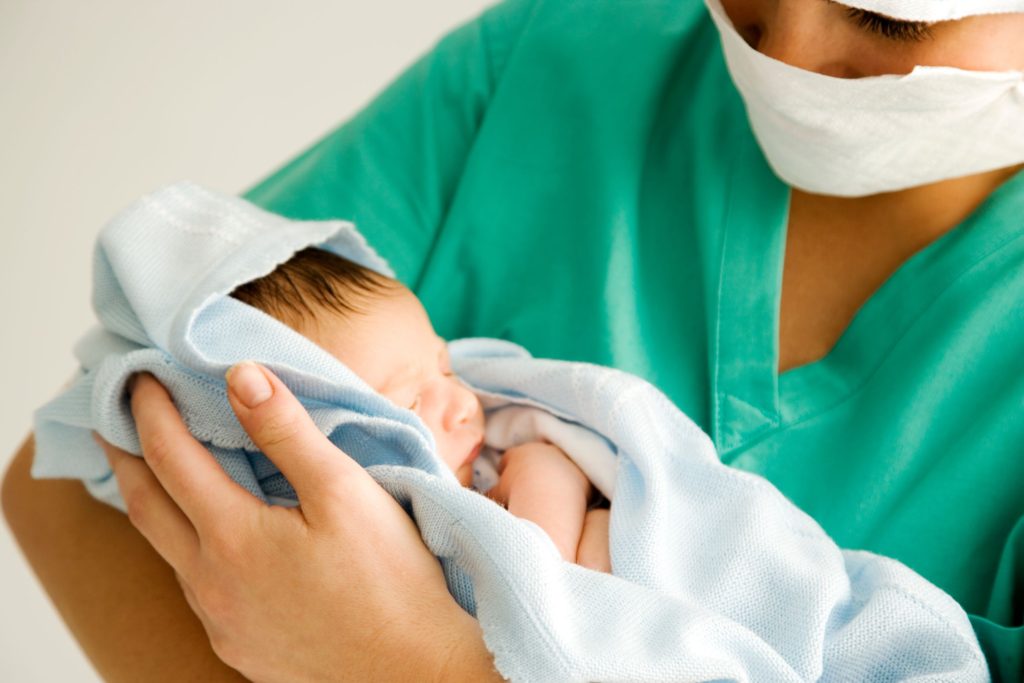 Midwife holding newborn baby