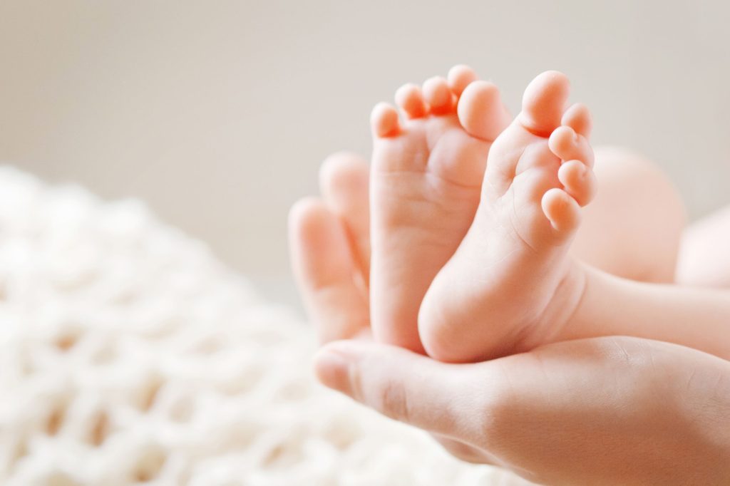 Close up of mother holding their baby's feet