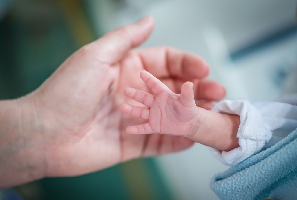 Close up of mother holding their baby's hand