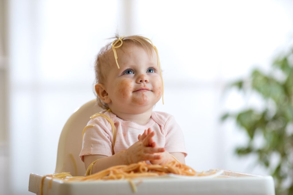 cute baby with spaghetti on her head 