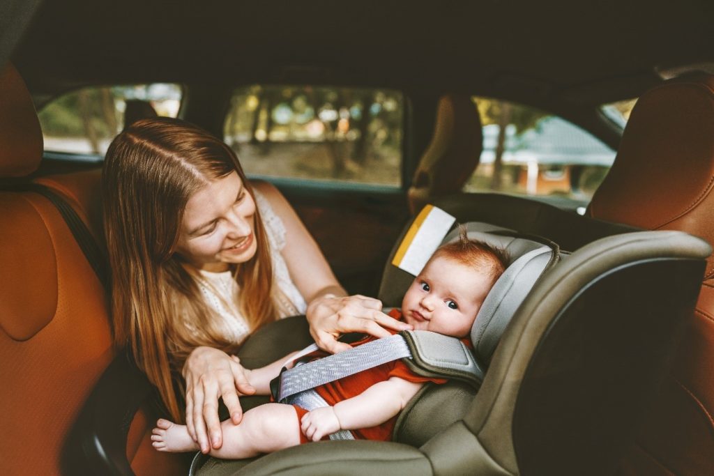 Mum smiling at baby in car seat