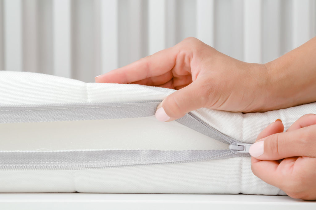 Woman unzipping baby mattress