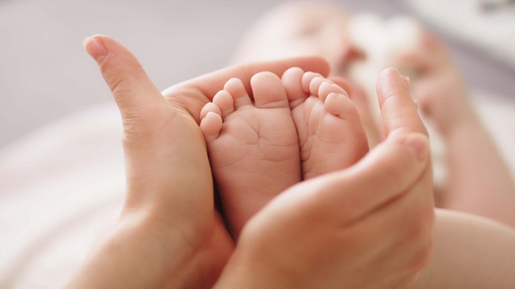 Mother cradling her baby's tiny little feet
