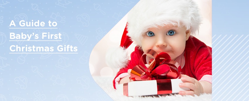 Cute baby in Santa hat with big blue eyes holding a present