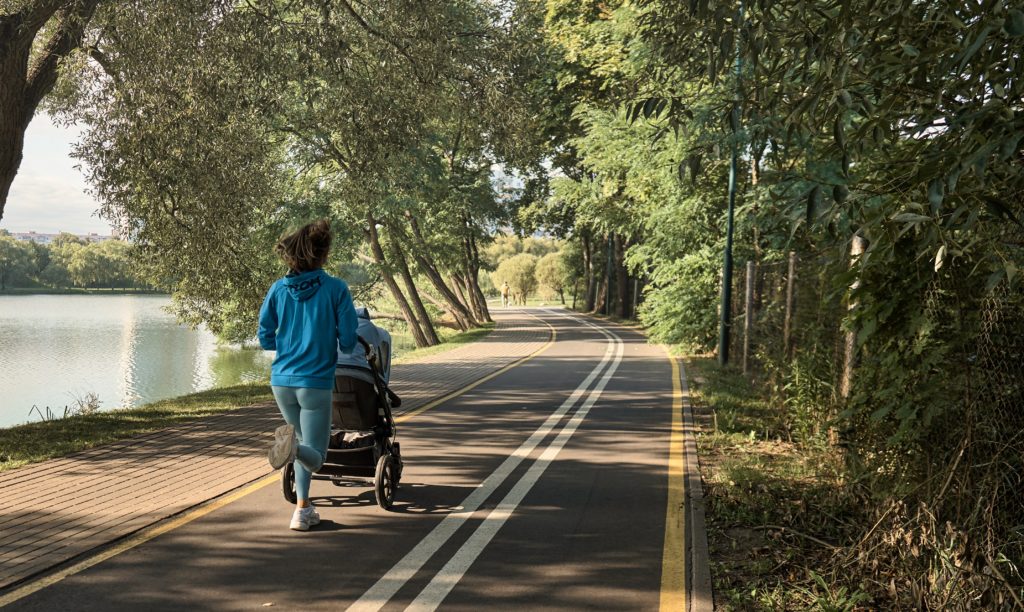 Woman in a blue top running with a pram