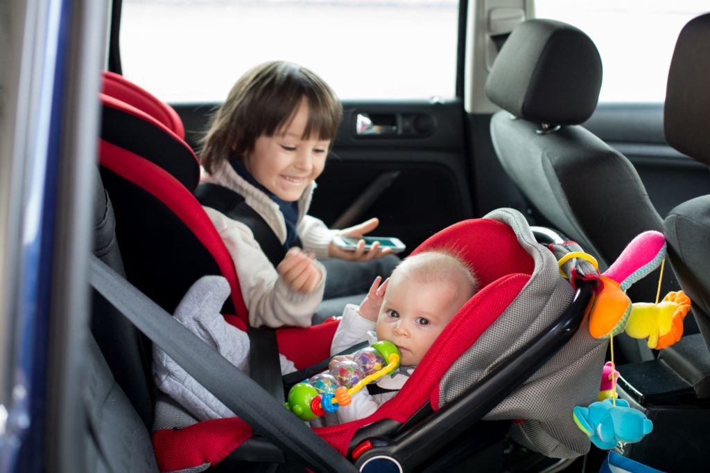 Siblings sat in their car seats in the back of the car