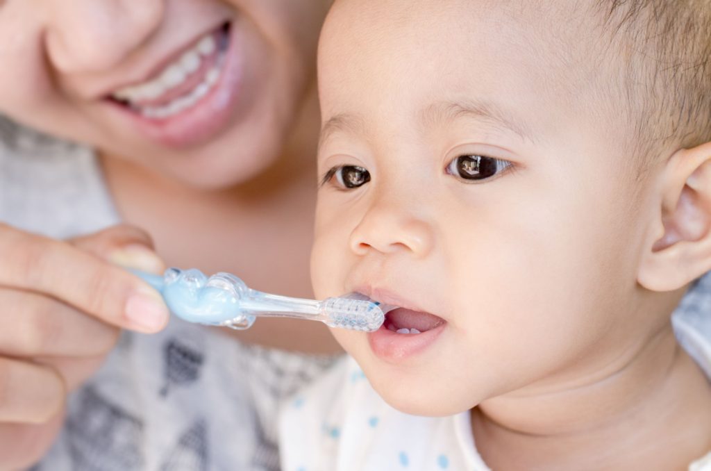 baby having teeth brushed