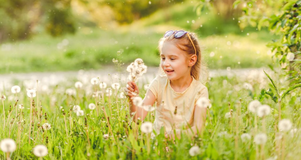 a child playing in a field of dandelions