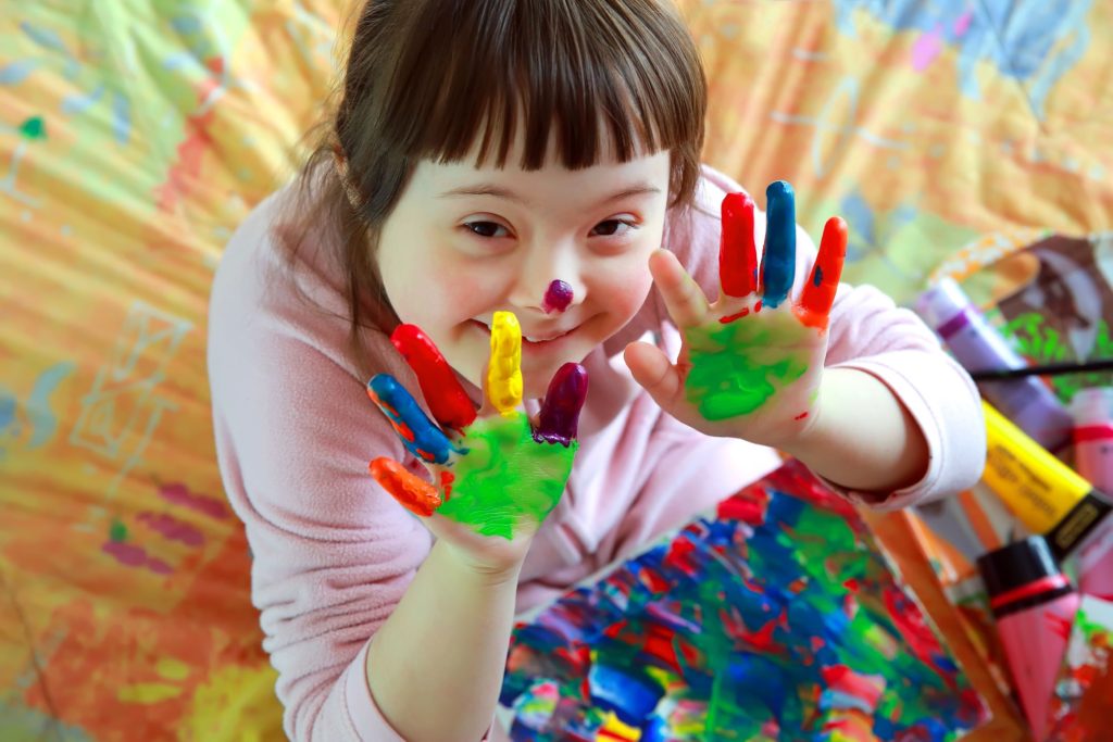 Little girl smiling with paint on her hands