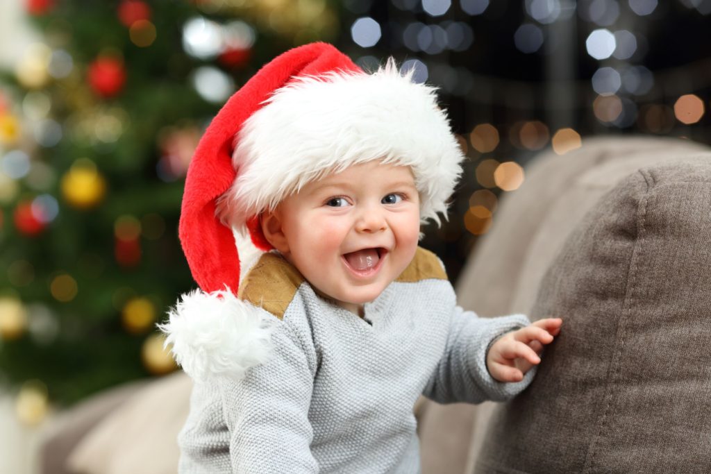 Baby laughing with Christmas hat on