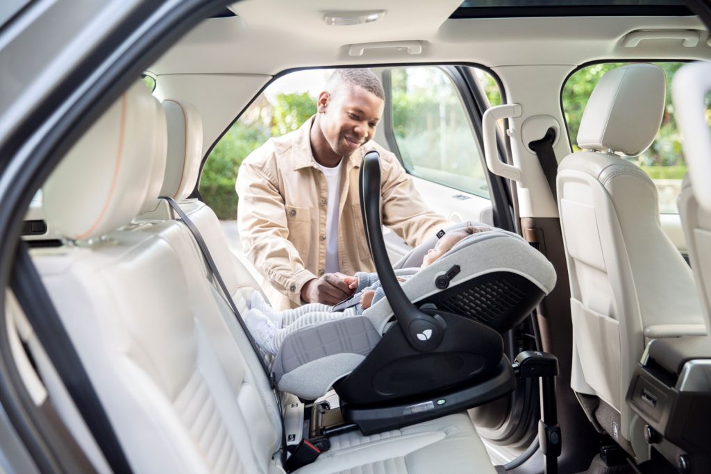 Dad smiling at baby in their car seat that has an i-Encore base
