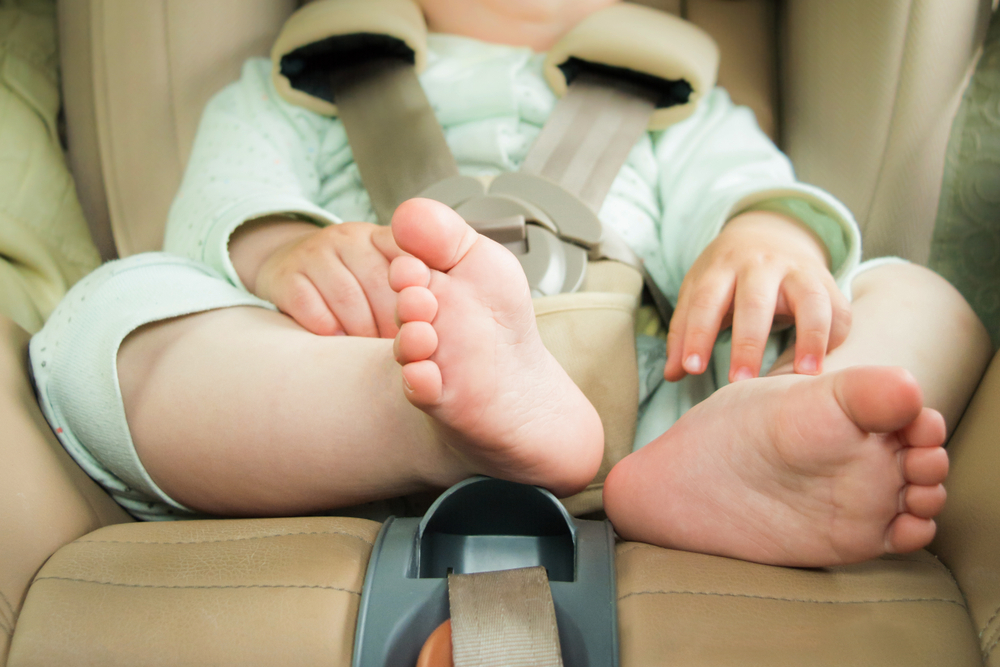 Small Baby Sitting In Special Car Seat With Safety Seatbelts