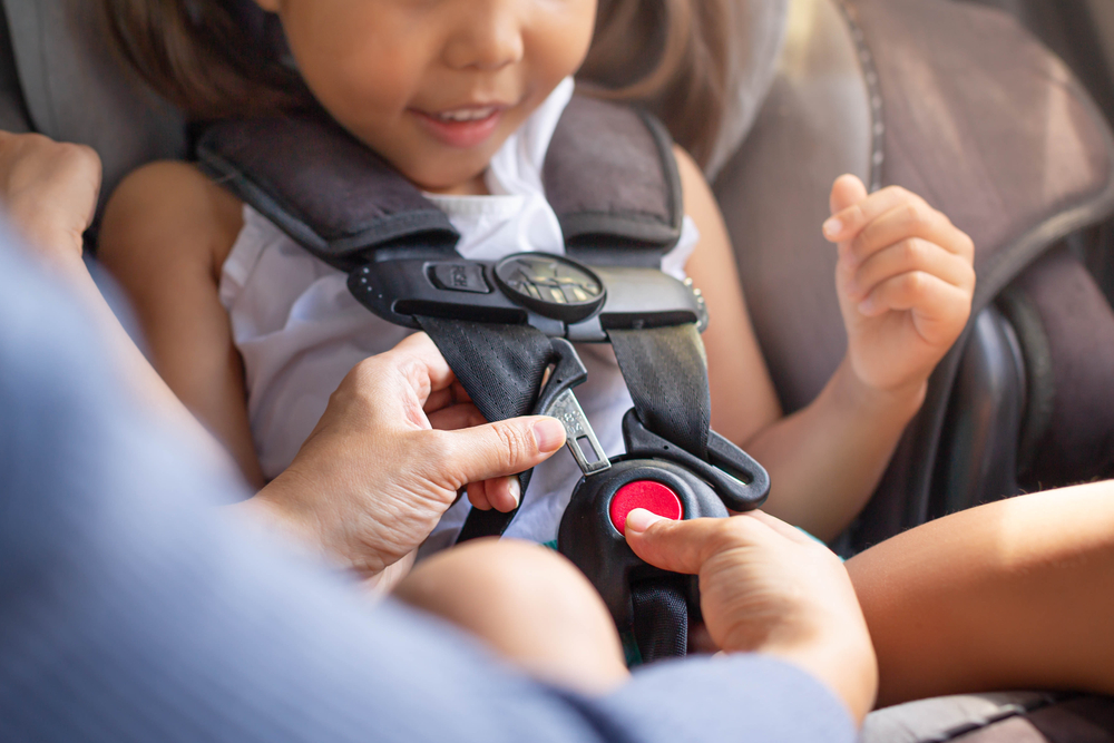 Parent,Buckling,Her,Child's,Seat,Belt,In,The,Car.,Transportation