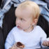 Infant,Baby,Kid,Eating,Cream,Dessert,Sitting,On,Stroller.,Closeup